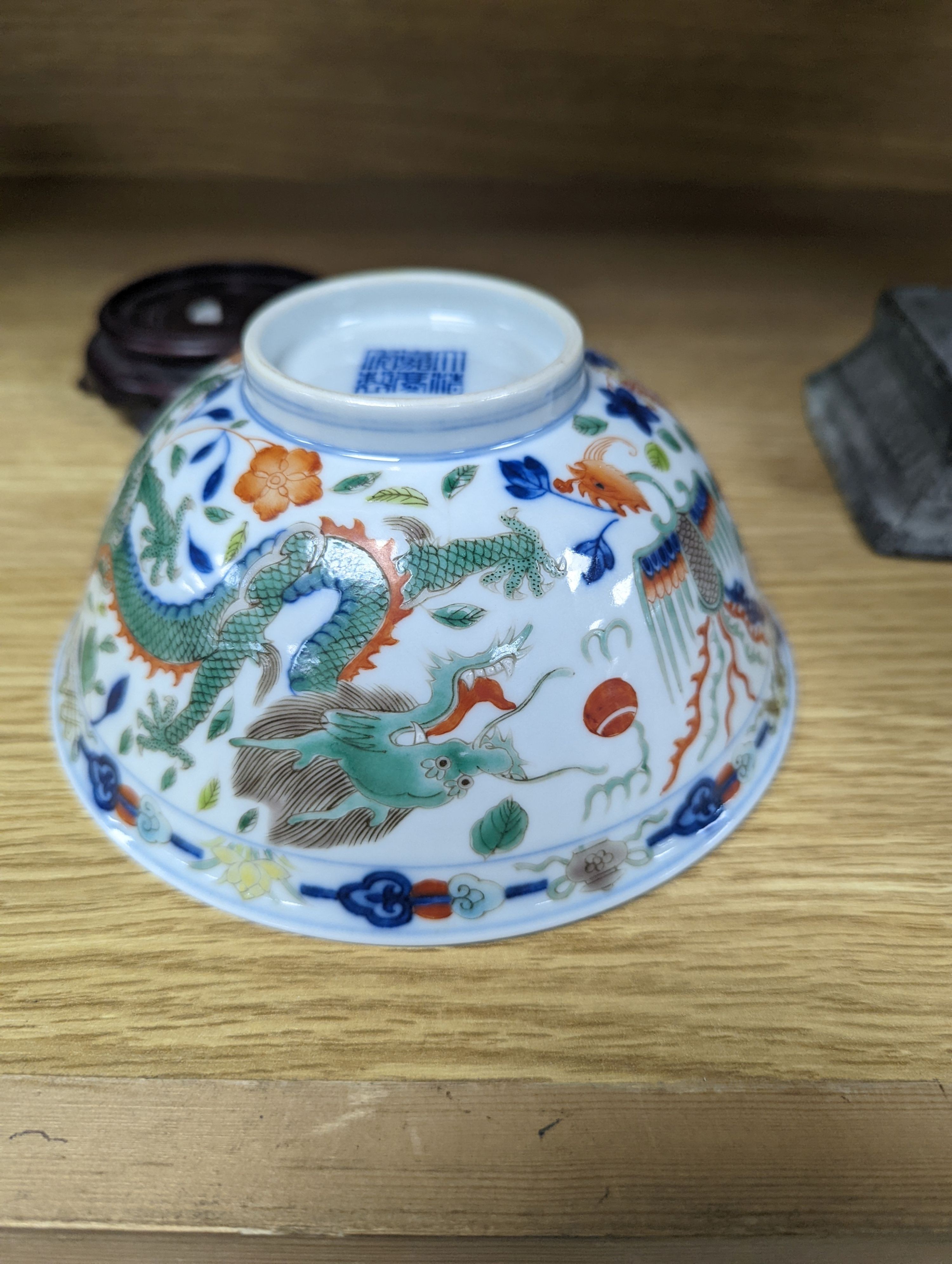 A Wucai bowl, dragon and flamingo pearl decoration, Jiaqing mark, on wood stand. 16cm diameter